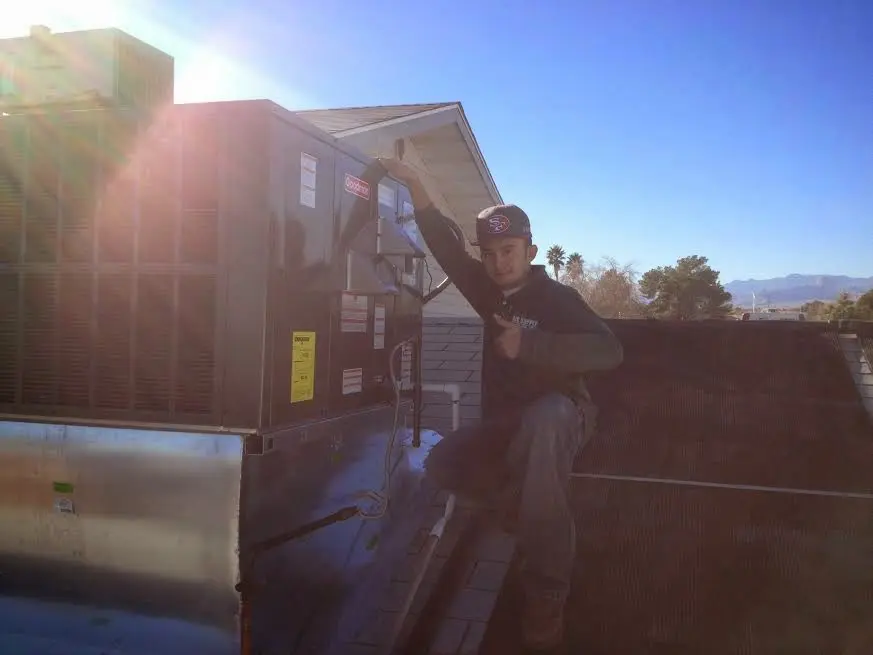 HVAC technician performing AC Tune-Up on a rooftop unit in Millville